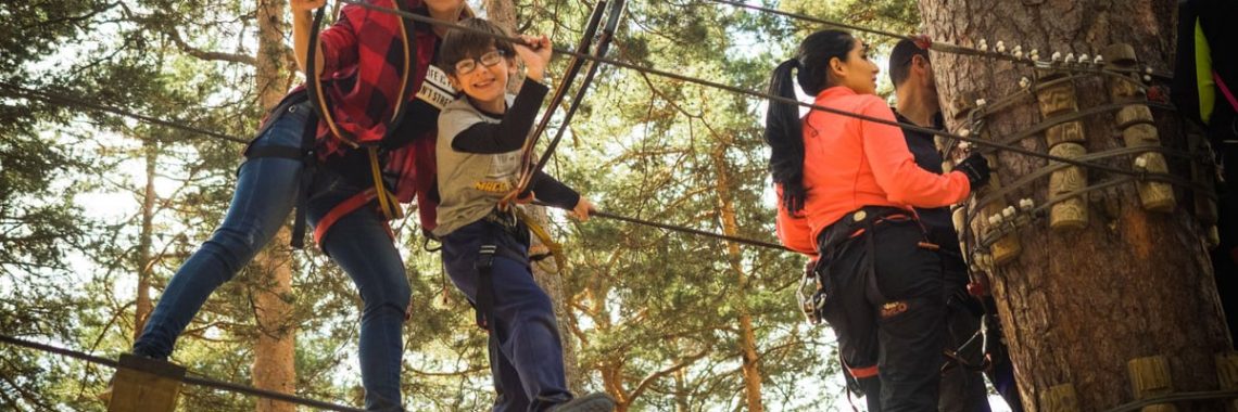A family enjoys a thrilling day on a ropes course in Cercedilla, Spain.